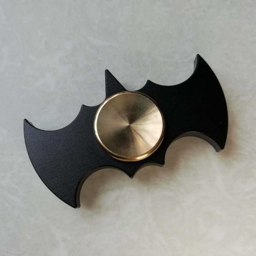 Fidget spinner with bat emblem design on a light gray background
