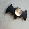 Black bat-shaped fidget spinner with a gold center on a light gray background