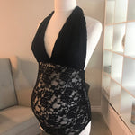 Black lace dress on a mannequin against a neutral background