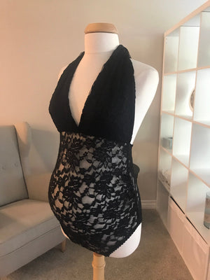 Black lace dress on a mannequin against a neutral background