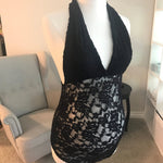 Black lace top on a mannequin in a room with a sofa and lamp.