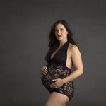 Woman wearing a black lace bodysuit against a dark background