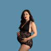 Woman wearing a black lace bodysuit against a dark background