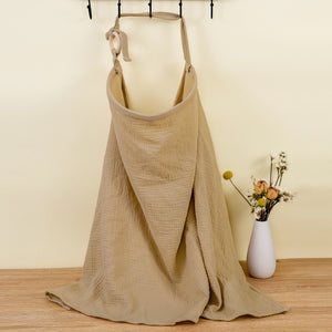 Beige apron on a hanger with a vase of flowers on a wooden surface.