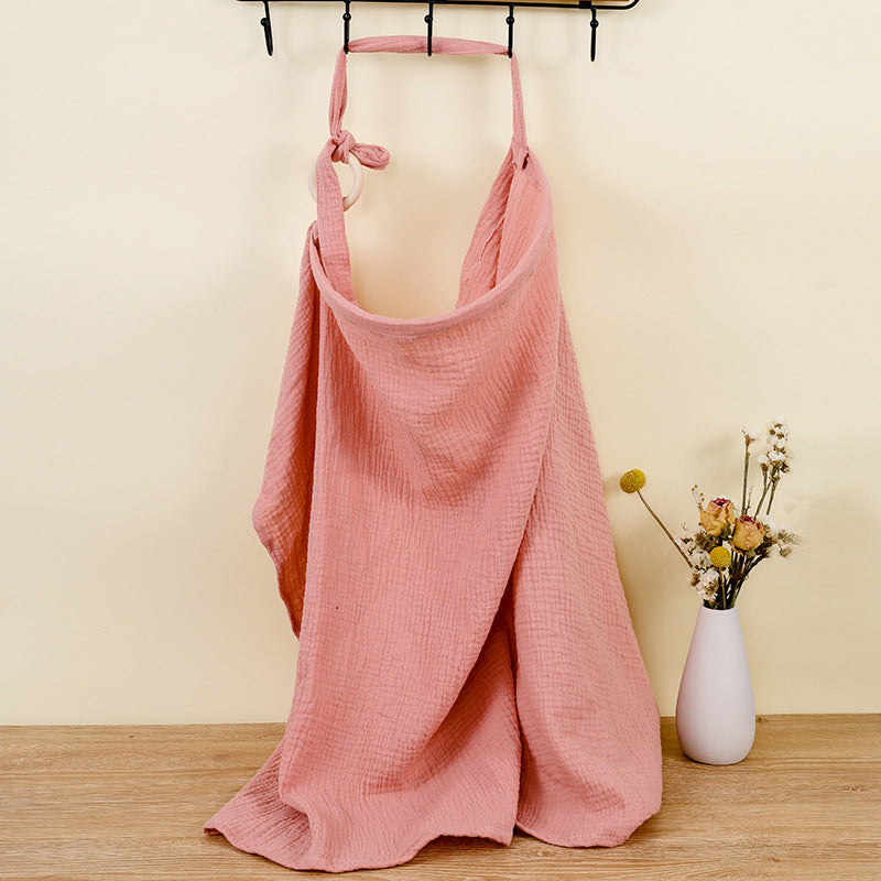 Pink dress hanging on a rack with a vase of flowers on a wooden surface.
