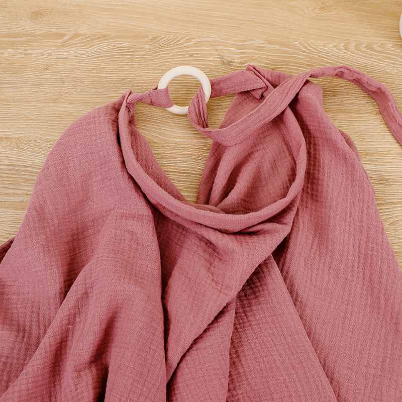 Pink fabric draped over a hanger on a wooden surface
