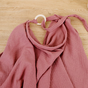 Pink fabric draped over a hanger on a wooden surface