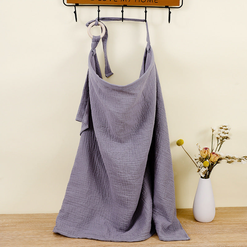 Purple dress hanging on a rack with a vase of flowers on a wooden floor.