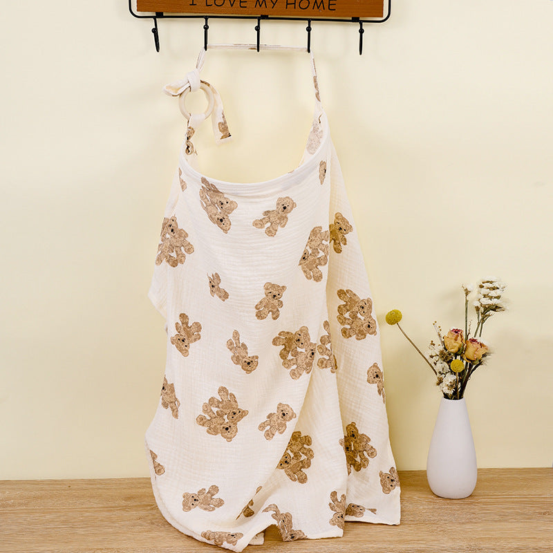 White tank top with teddy bear pattern on a wooden surface with a vase of flowers in the background.
