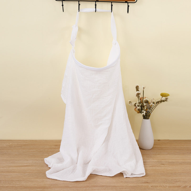 White sleeveless top on a mannequin against a beige wall with a vase of flowers on a wooden surface.