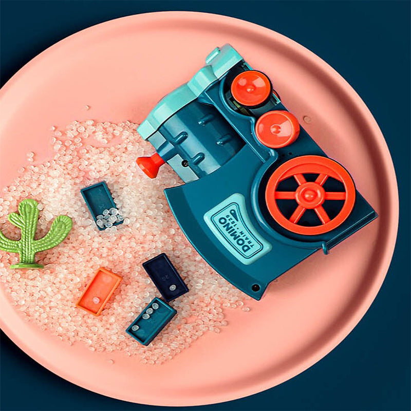 Toy drill with sand and small toys on a pink plate against a dark blue background