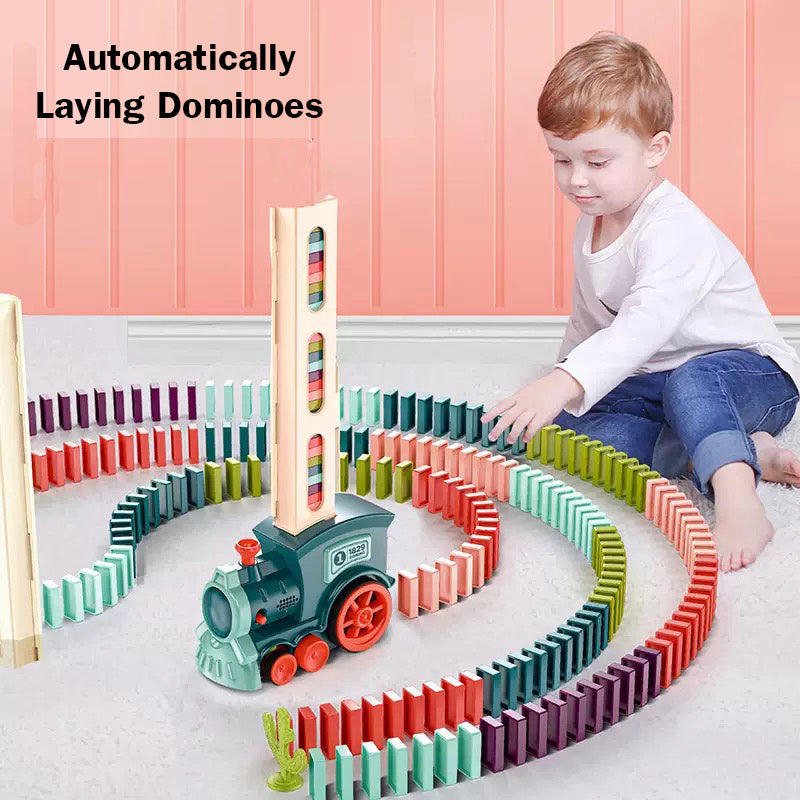 Child playing with a colorful domino set and train toy on a pink floor.