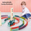 Child playing with a colorful domino set and train toy on a pink floor.