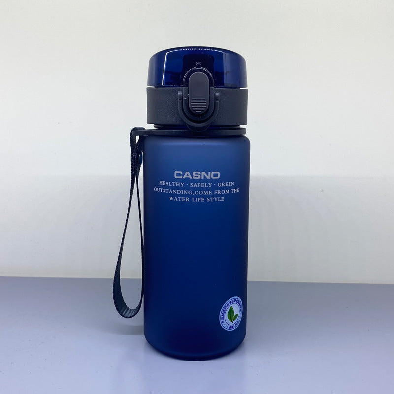 Blue water bottle with black lid and handle on a light gray surface with white background
