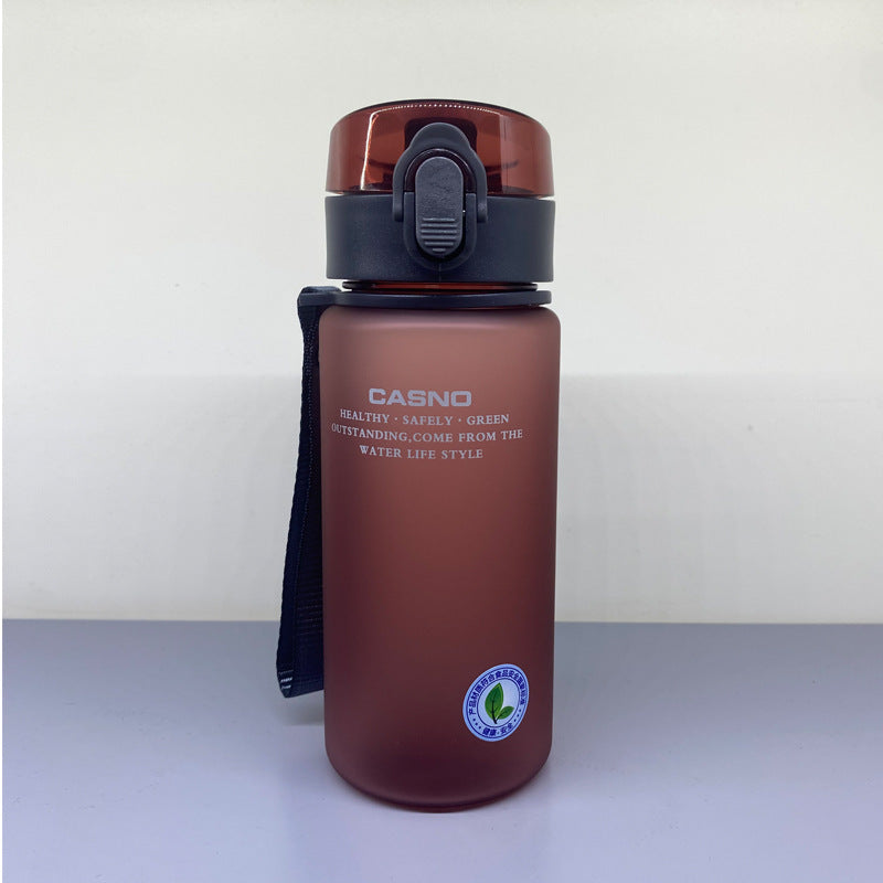 Brown water bottle with black lid and strap on a light gray surface with a white background