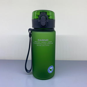 Green water bottle with black lid and strap on a light gray background