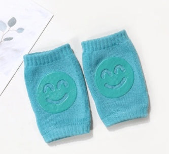 Pair of blue knee pads with smiley face designs on a white background