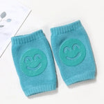 Pair of blue knee pads with smiley face designs on a white background