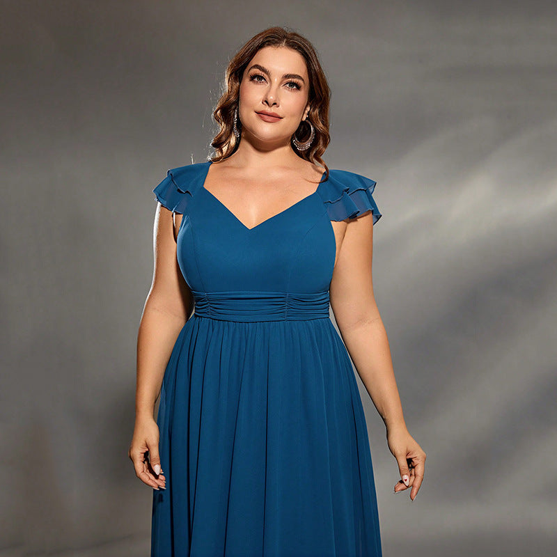 Woman wearing a blue dress against a gray background