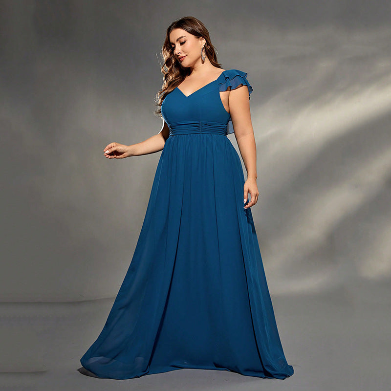 Woman wearing a blue evening gown against a gray background