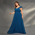 Woman wearing a blue evening gown against a gray background