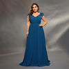Woman wearing a blue evening gown against a gray background
