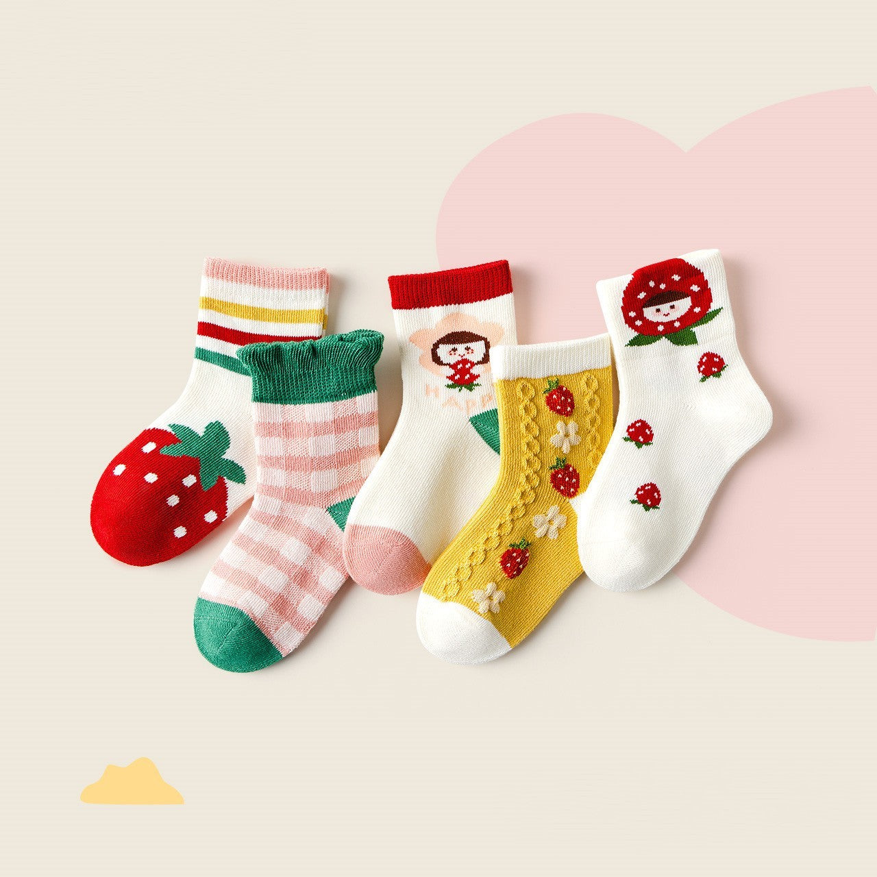 Set of colorful children's socks with strawberry design on a light pink background