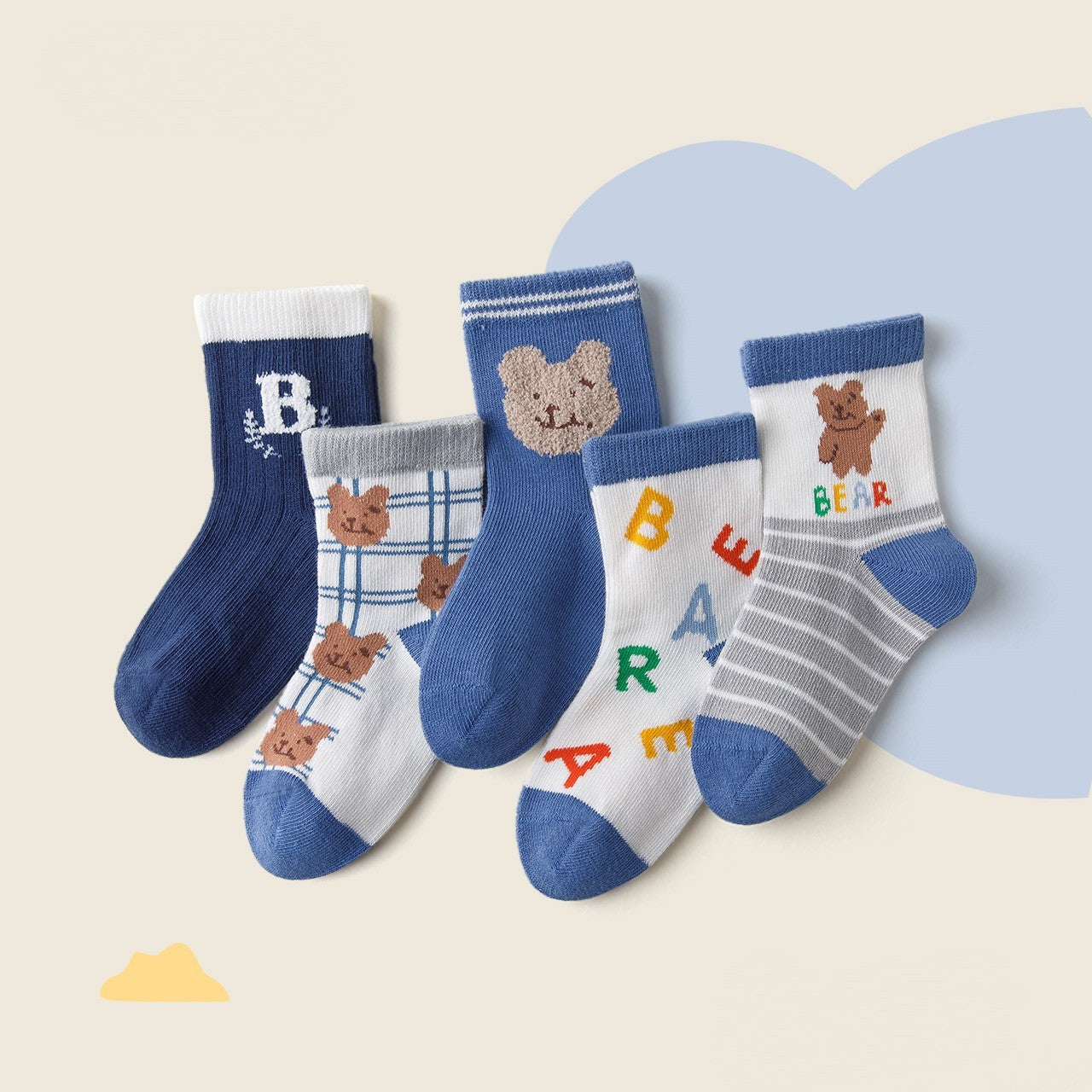 Set of baby socks with bear and alphabet design on a light background