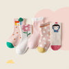 Set of colorful children's socks with various designs on a light pink background