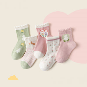 Set of five children's socks with various patterns on a light pink background