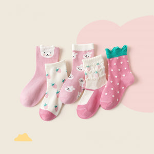 Set of five children's socks with various designs on a light pink background