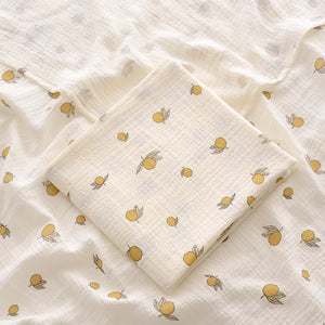 White fabric with yellow lemon pattern, folded neatly.