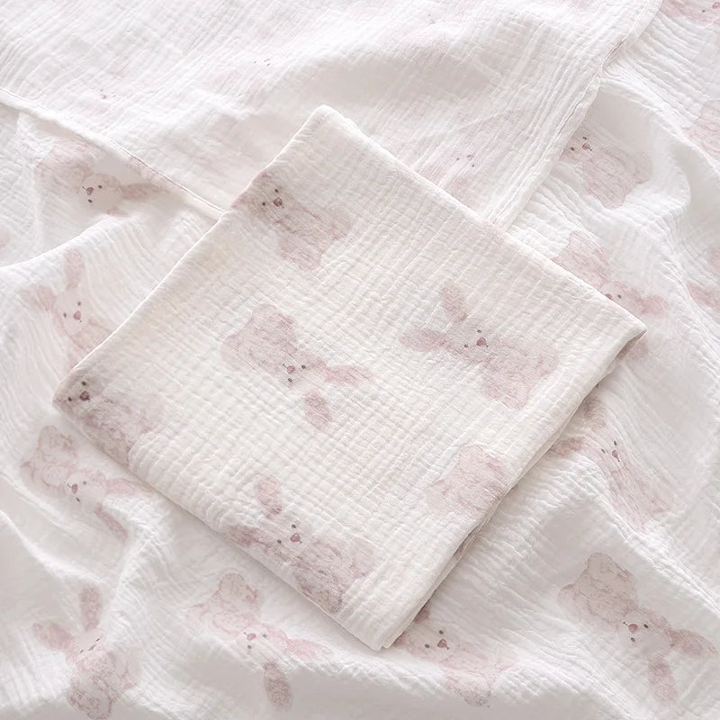 Stack of white fabric swaddles with pink floral patterns