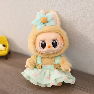 Cute plush toy with bunny ears and a dress on a wooden surface.