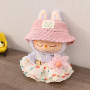 Toy figure with a pink hat and floral skirt on a wooden surface