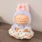 Plush toy with a purple hood and floral accessory on a wooden surface