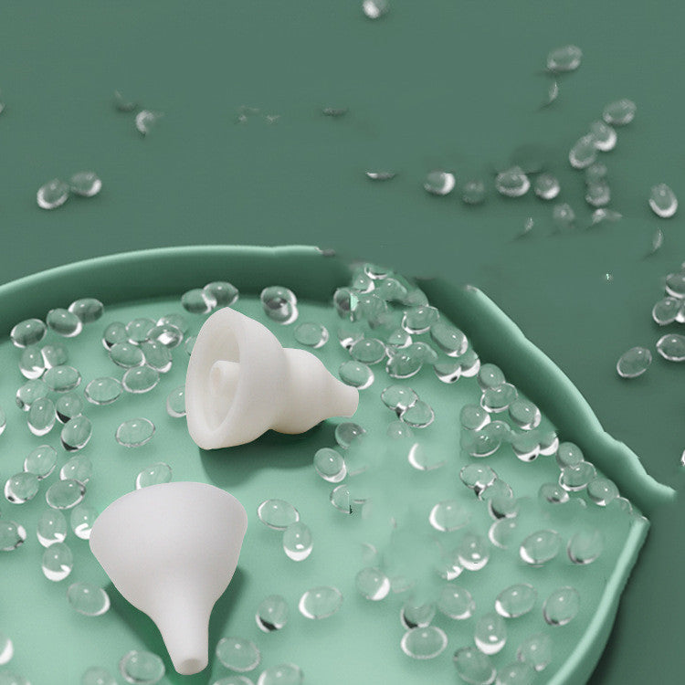 Two white silicone funnels on a green surface with clear gel-like substance around them.