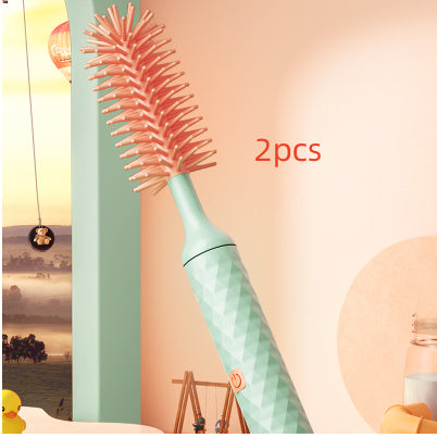 Bottle brush with pink bristles and a light blue handle on a colorful background