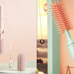 Set of hairbrushes and styling tools on a light pink background