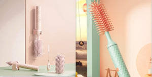 Set of hairbrushes and styling tools on a light pink background