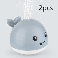 Two gray whale-shaped bath toys with a white base on a light background.