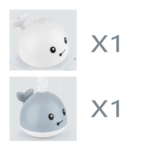 Two cartoon-style whale bath toys with smiling faces on a white background.