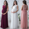 Three women wearing long, elegant dresses in front of a white brick wall.