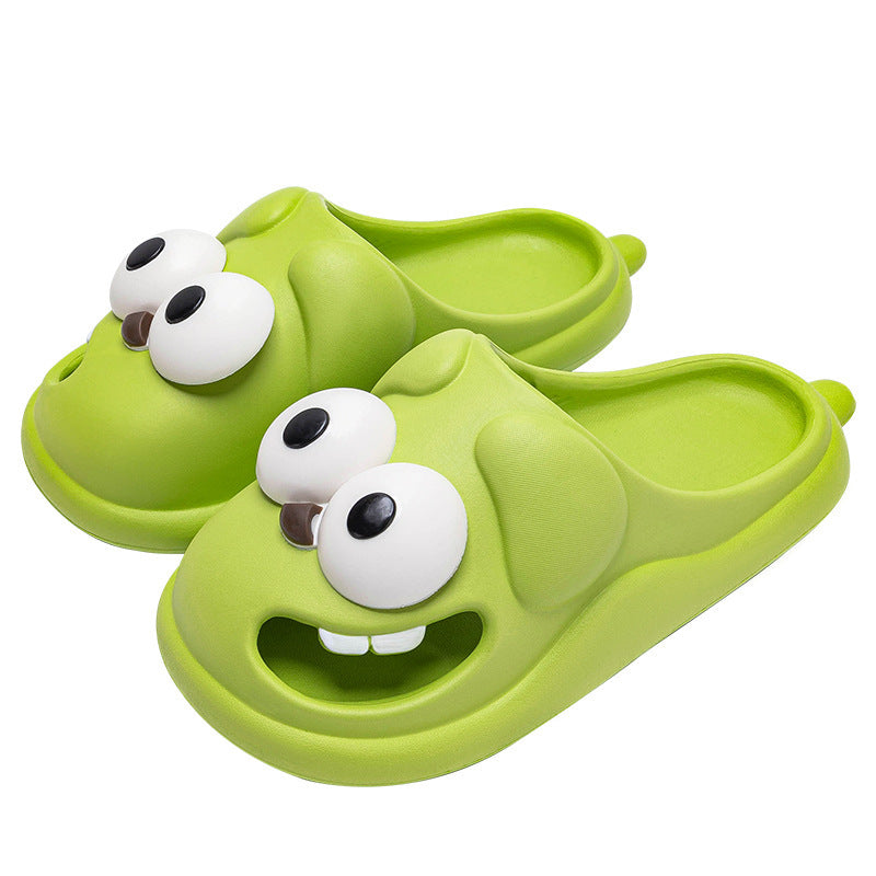 Green children's sandals with cartoonish face design on a white background