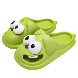 Green children's sandals with cartoonish face design on a white background