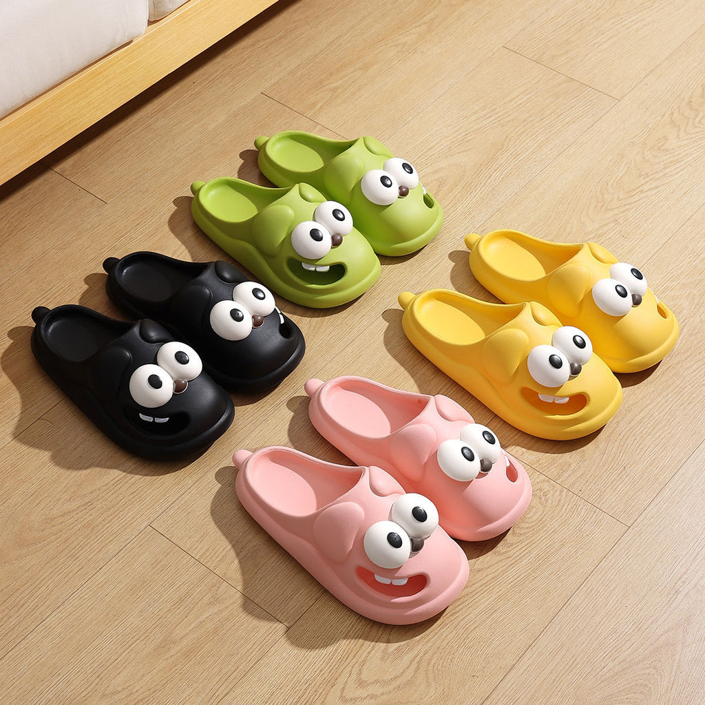 Set of colorful cartoon slippers with googly eyes on a wooden floor.