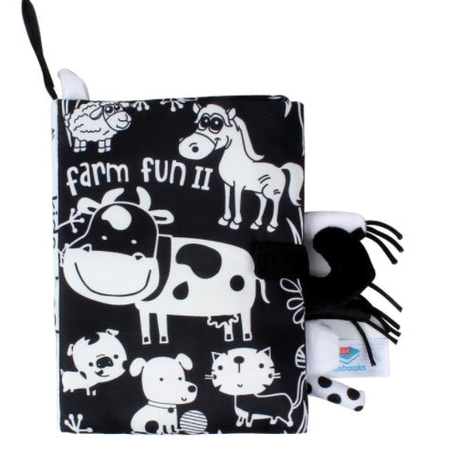 Black and white children's book with farm animal illustrations and a matching soft toy on a white background.