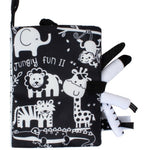 Black and white soft book with animal illustrations and a teether on a white background