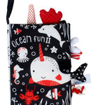 Children's soft book with ocean-themed illustrations on a black background