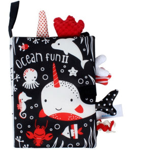 Children's soft book with ocean-themed illustrations on a black background